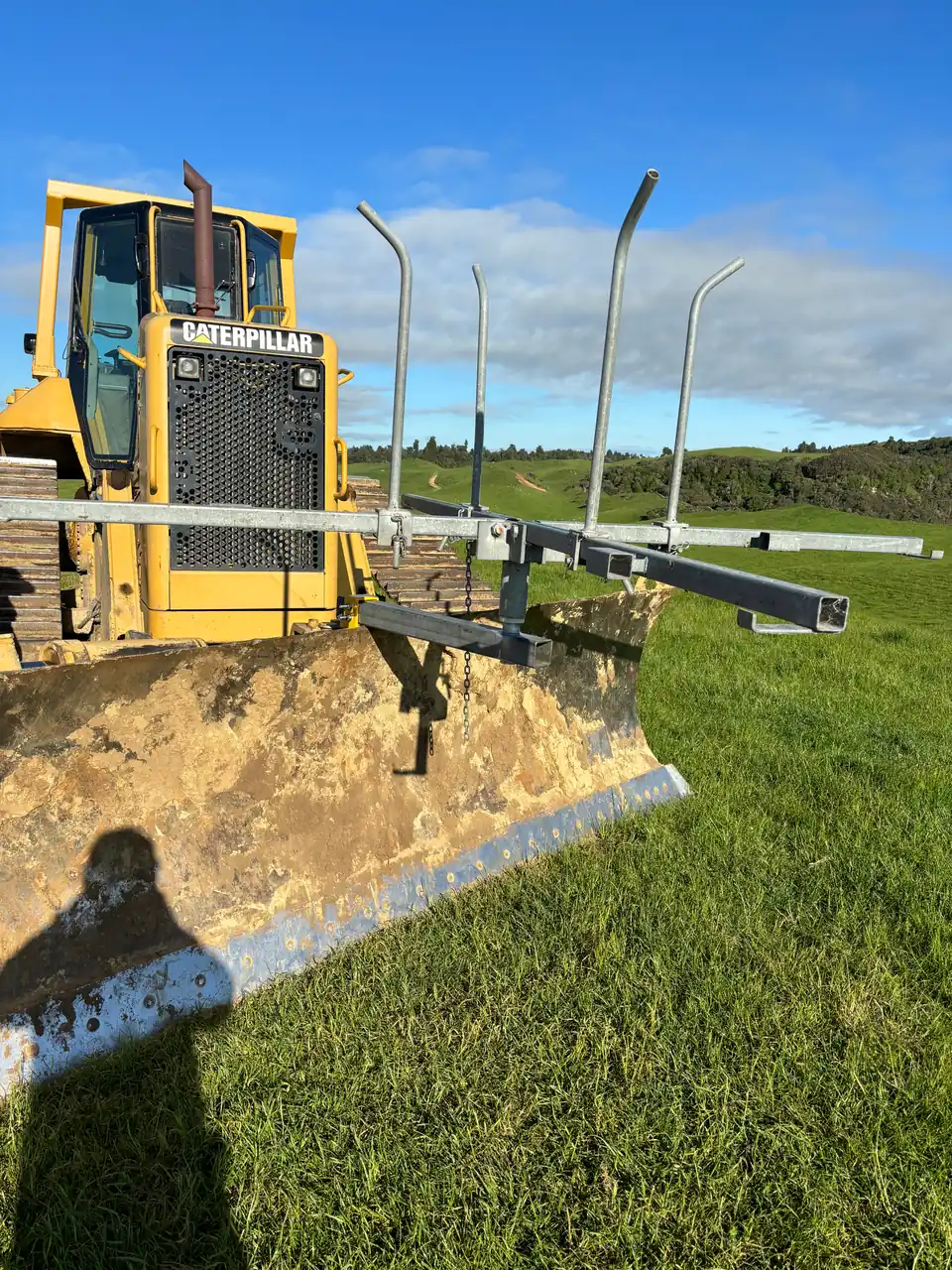 Caterpillar bulldozer working on a green paddock