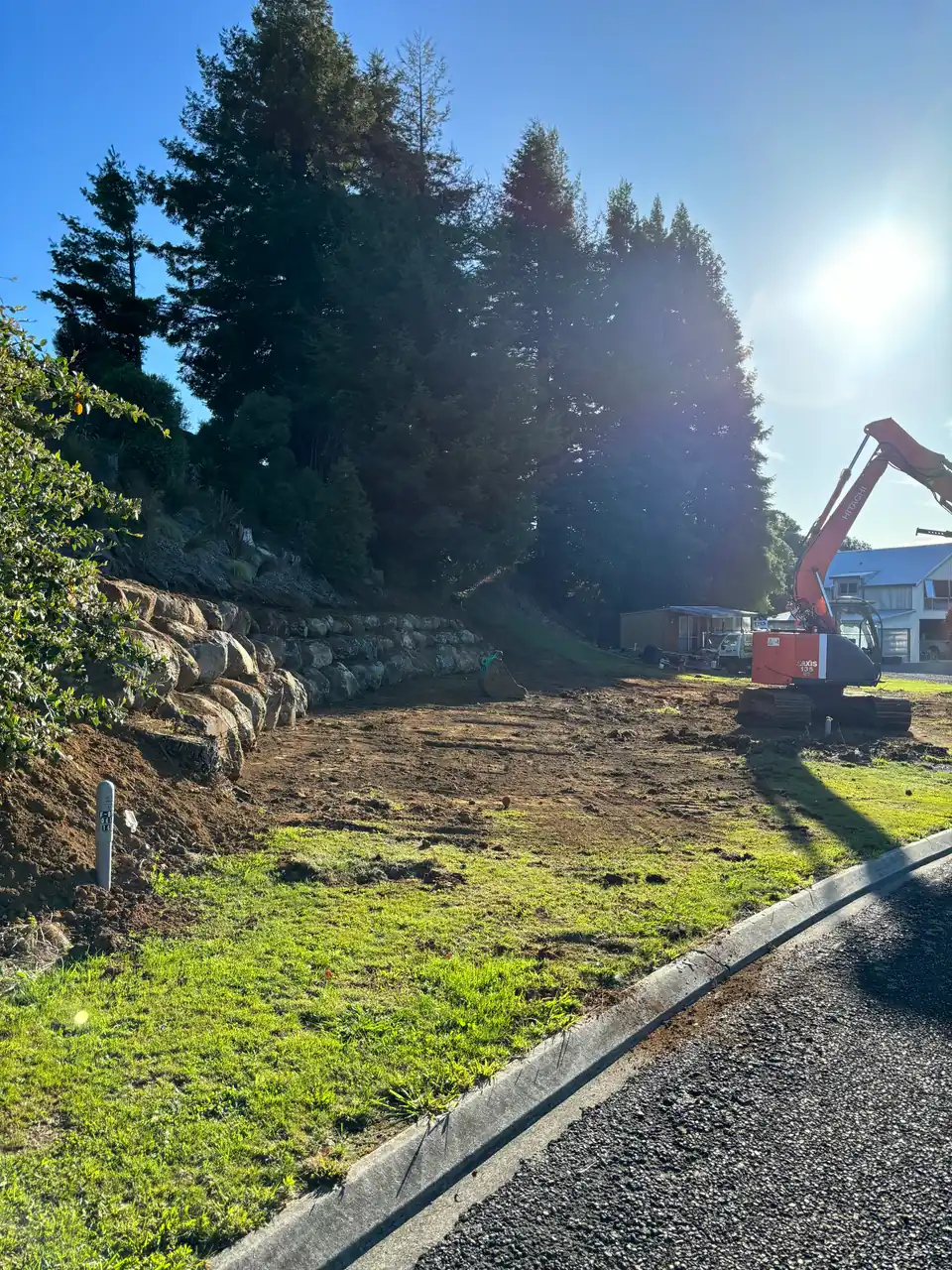 Excavator shaping a section with new edging and gravel path