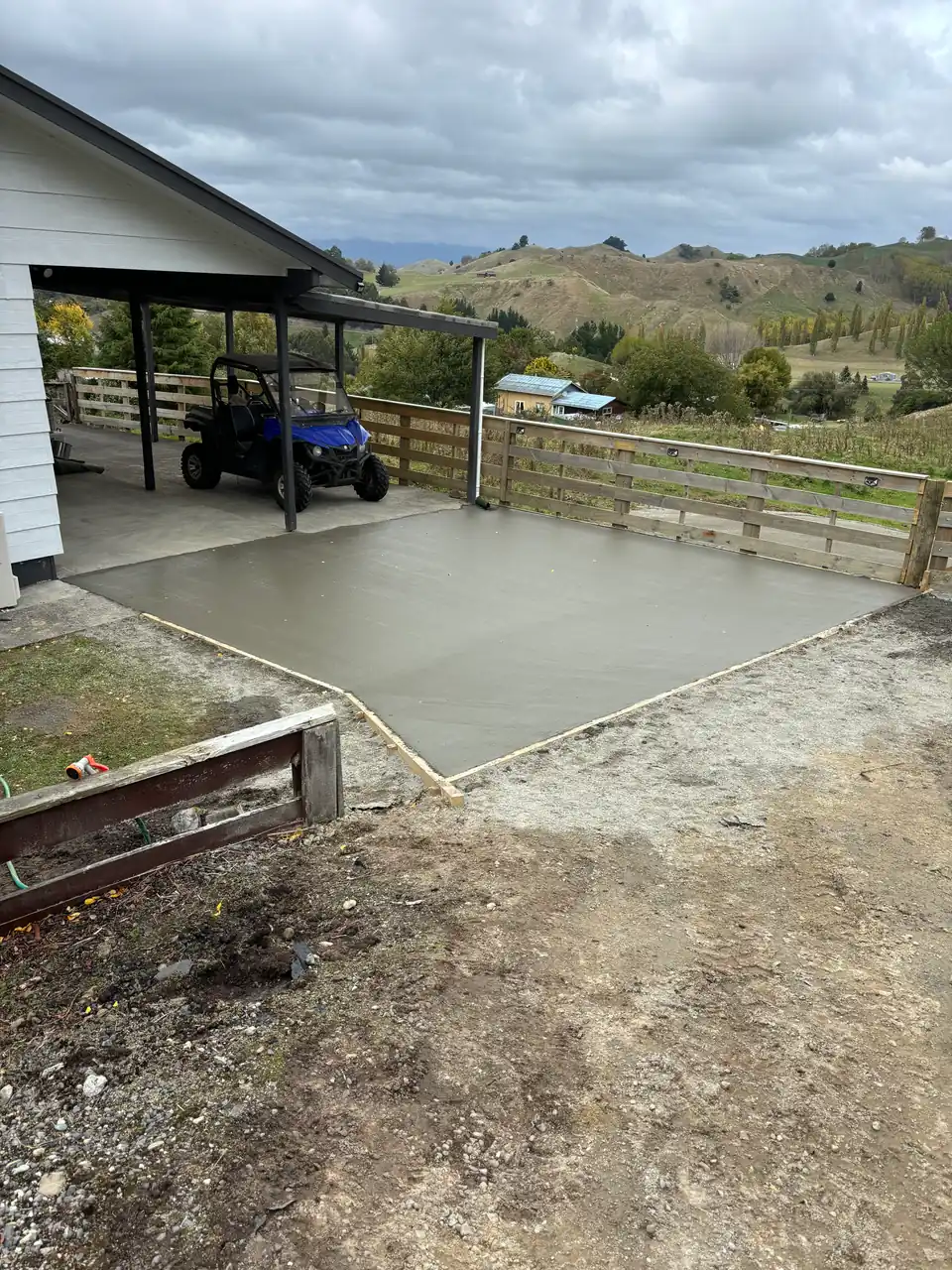 New concrete pad poured beside a farm shed