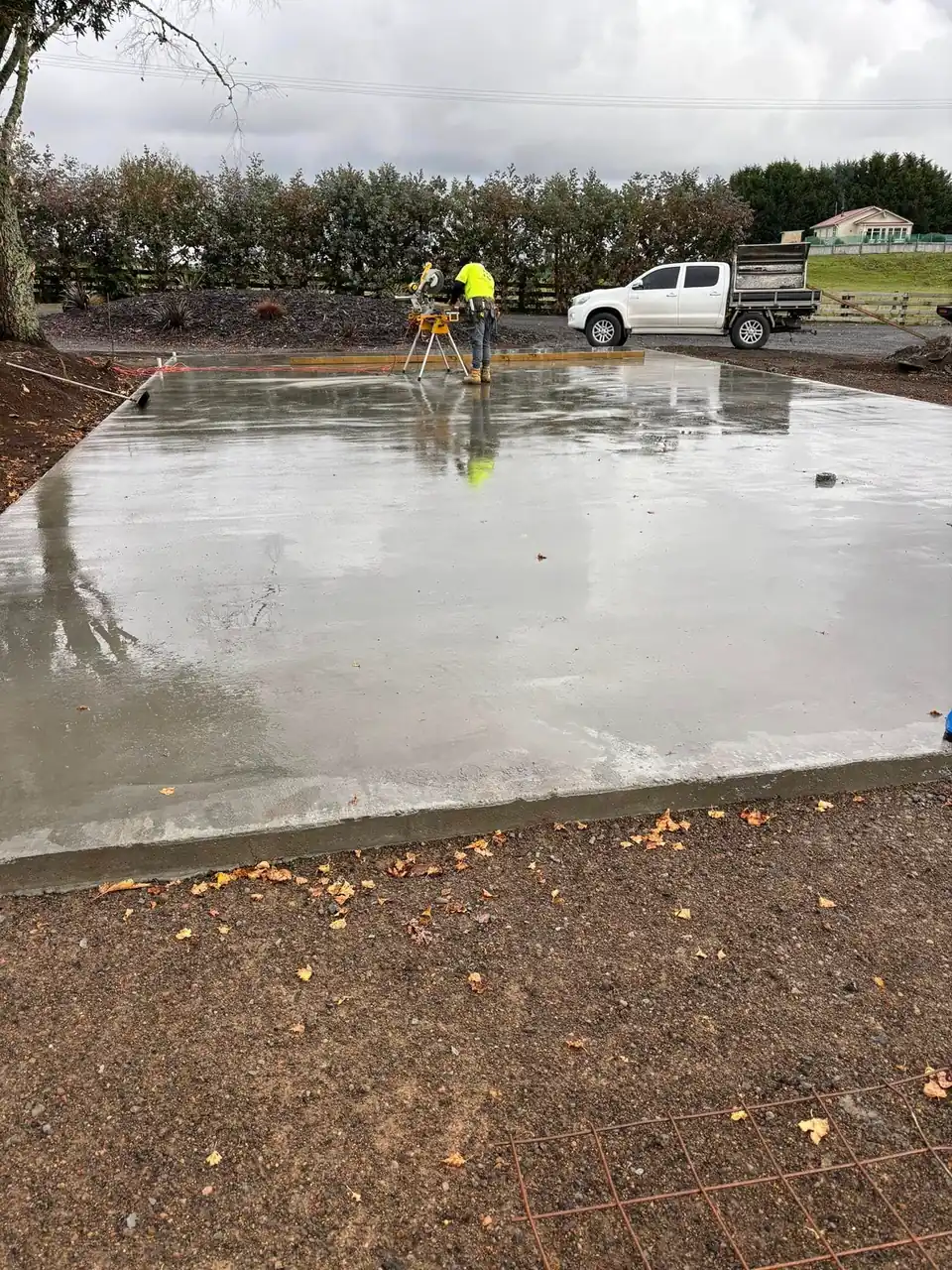 Freshly finished concrete slab with the crew working behind