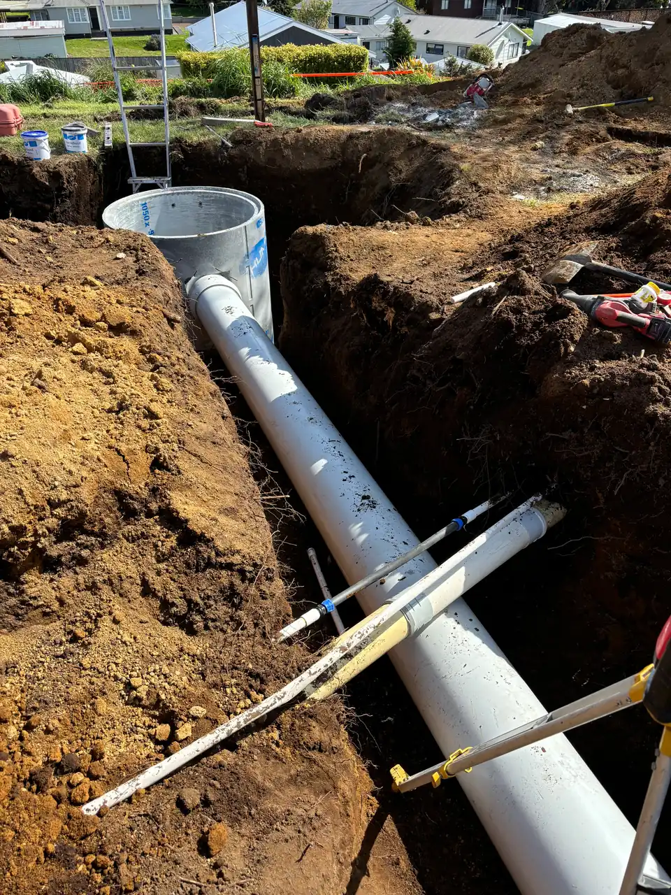 Stormwater pipe running into a concrete chamber in an open trench
